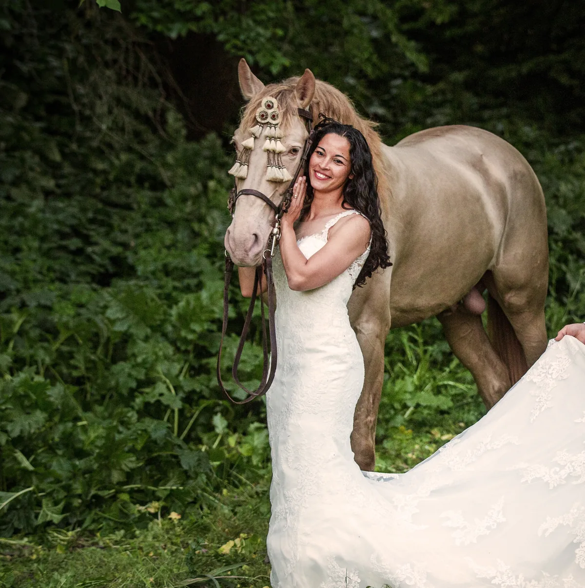 Angelina Zanker in a wedding dress beside a cremello stallion